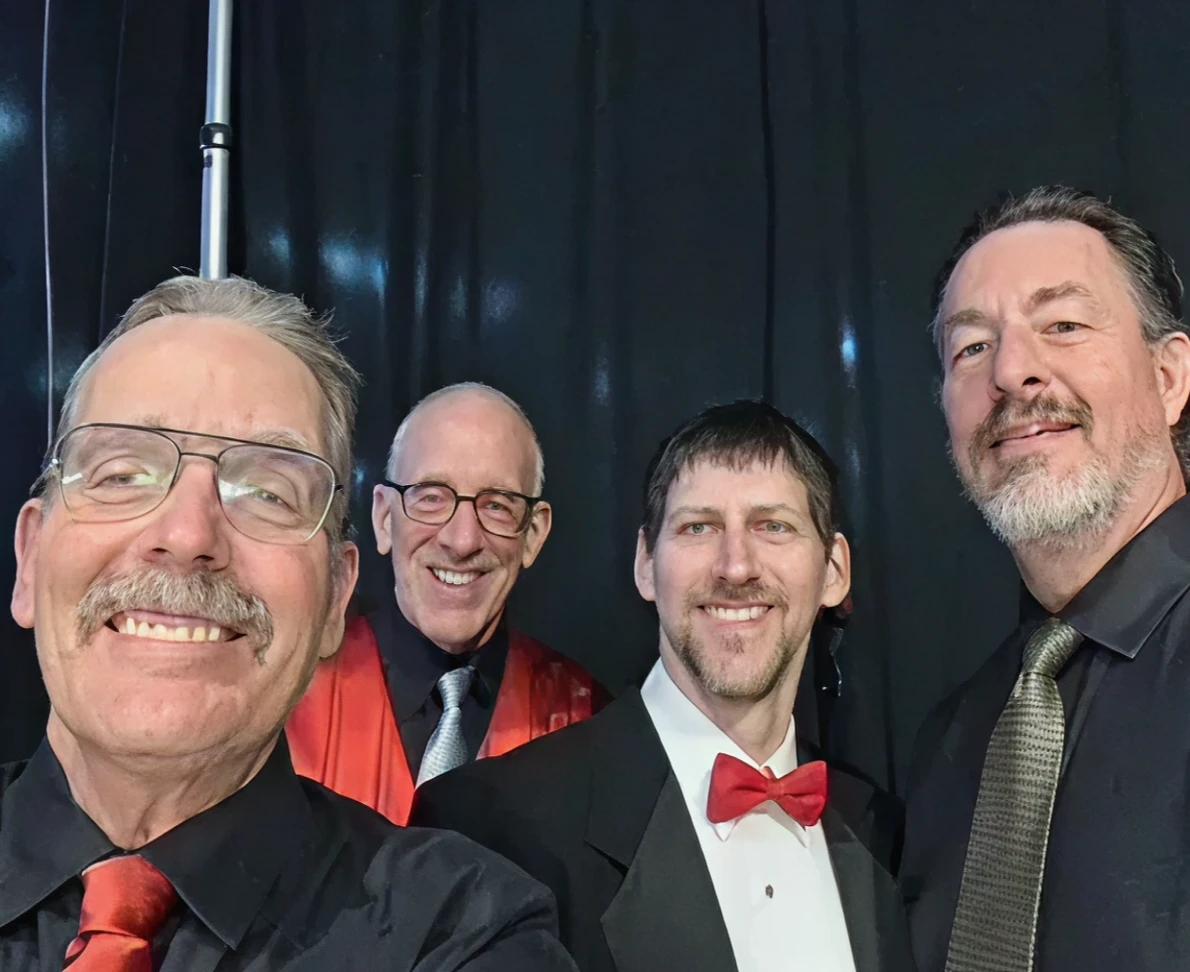 Four men in formal attire smiling